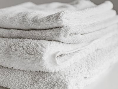 Stack of clean white towels and a bottle of water